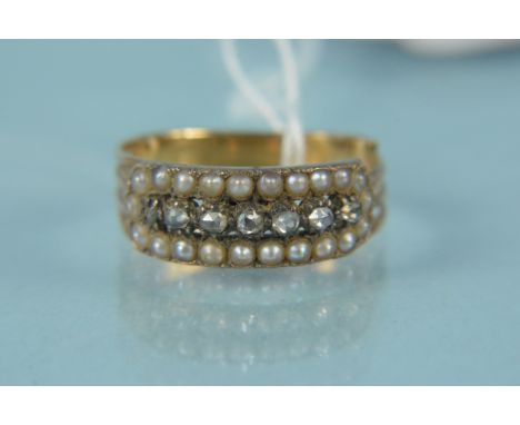 An antique yellow metal diamond and seed pearl set ring, the centre row of old cut diamonds with seed pearl border, split sho