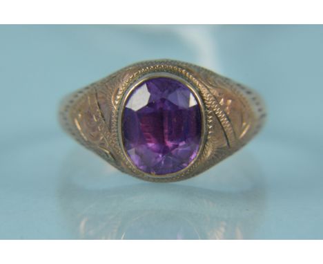 A yellow metal ring set with a purple stone (hallmarks rubbed), size T 1/2, weight approx 3g