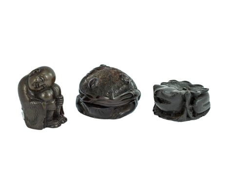 A Collection of Three Oriental Okimonos, the first appears to be  a carved horn in the form of a Buddha in a crouched positio