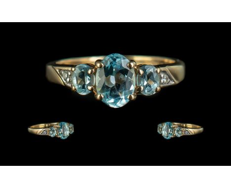 Ladies 9ct Gold Attractive 3 Stone Aquamarine Set Ring with Diamond Set Shoulders. Full Hallmark to Interior of Shank. The Aq