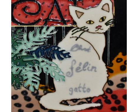 An assorted collection of decorative art and coloured prints, including a glazed ceramic cat themed tile and a limited editio