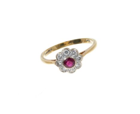 Ruby and diamond daisy cluster ring with a central round mixed cut ruby measuring approximately 3.7mm surrounded by a border 