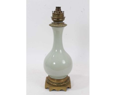 19th century French celadon glazed porcelain lamp with brass mounts, the baluster shape body on a case brass plinth base, 40c