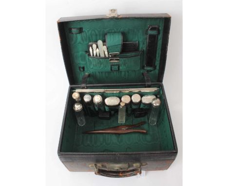 Victorian green leather toilet case, with lift out fitting, containing an assortment of Victorian and later silver topped bot