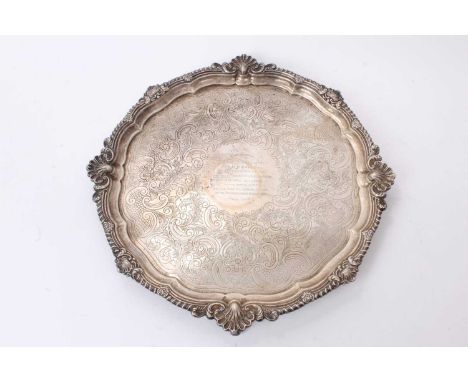 Edwardian silver salver of circular form, with shell and gadrooned border and engraved presentation inscription, on four scro