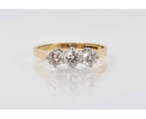 Diamond three stone ring with three brilliant cut diamonds in claw setting on 18ct gold shank. Estimated total diamond weight