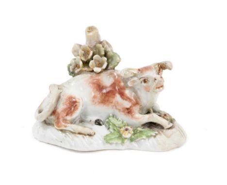 A Derby model of a recumbent cow, circa 1770, polychrome decorated, 9.5cm wideRestoration to bocage, horns, base, tail, legs 