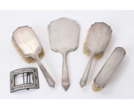 Three 1930s Art Deco style silver mounted dressing table brushes and a matching hand mirror (Birmingham 1932), together with 