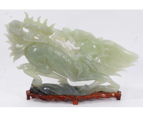 Large Chinese jade or green hardstone carving of a mythical beast, raised on wooden plinth, 43cm long