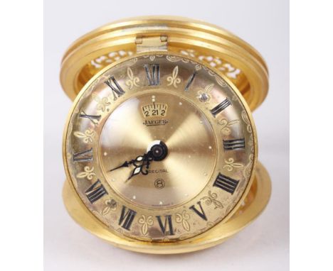 A Jaeger travelling alarm clock with gilt dial and Roman numerals and scrolled and pierced case 