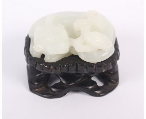 A Chinese celadon jade carving of a recumbent Kylin and clouds, 1 1/2" long, on carved hardwood baseCondition:No apparent dam