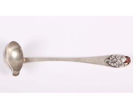 A Danish white metal sauce ladle with all-over planished decoration and amber cabochon to the finial 