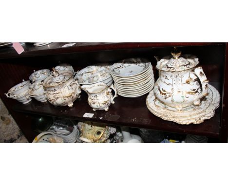 A Rockingham porcelain tea and coffee set, decorated in gilt with small green leaves, comprising twelve teacups and saucers, 