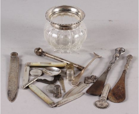 A moulded glass trinket jar with silver top, two silver handled shoe horns, two mother-of-pearl handled folding fruit knives 
