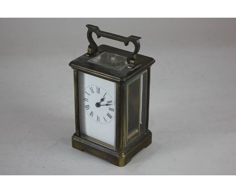 A brass carriage clock, with white enamel dial and Roman numerals, 14.5cm high