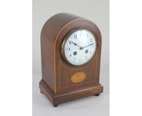 An Edwardian mahogany dome mantel clock the circular dial with Arabic numerals, the French movement half striking in a gong, 