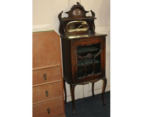 An Art Nouveau glazed cabinet, raised back with mirror shelf, all pierced, surmount above glazed door on slender cabriole leg