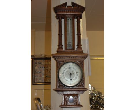 A 20th century carved oak cased aneroid barometer and thermometer, 75cm