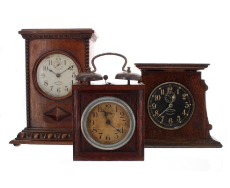 Three circa 1920 alarm clocks: one in a cottage industry style case with externally mounted bells, 9" high; an Ingersoll Radi