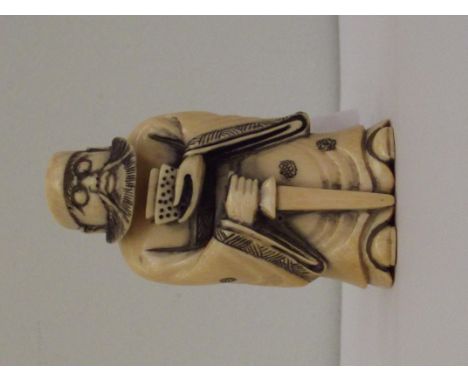 Carved ivory netsuke, in the form of a bearded man holding a sword, height 7cm