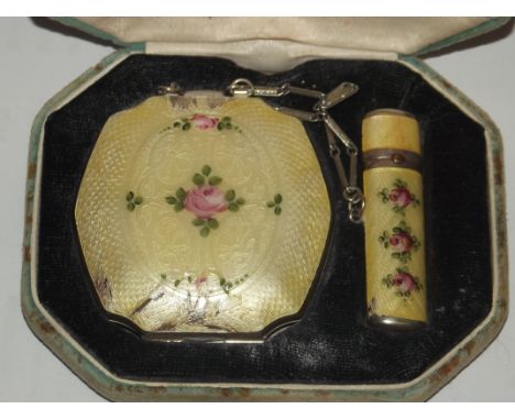 An early 20th century enamelled compact and lipstick cased set. Yellow enamel with floral design. Inside compact - mirror and