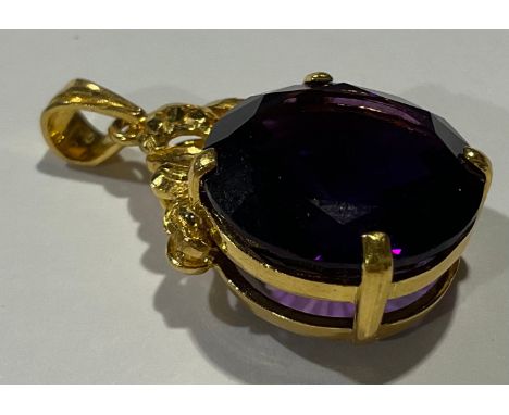 A gold coloured metal mounted Amethyst pendant, the large circular single stone facet cut, claw set, stamped '916' for 22ct g