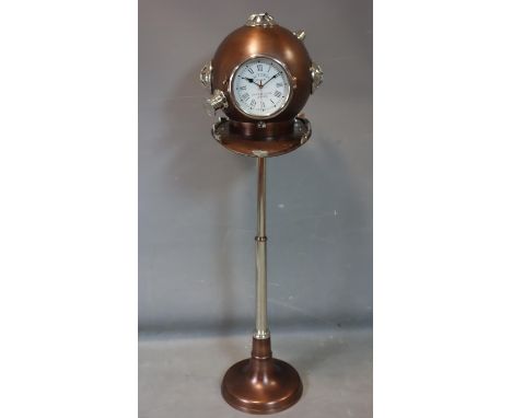 A contemporary clock in the form of a deep sea divers helmet on adjustable stand, H.124cm 