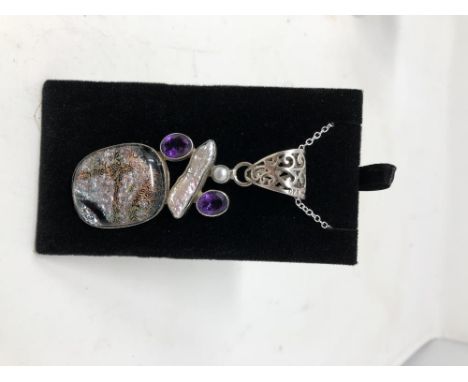 A silver pendant set with a cushion dichrok glass panel with pearl and amethyst.