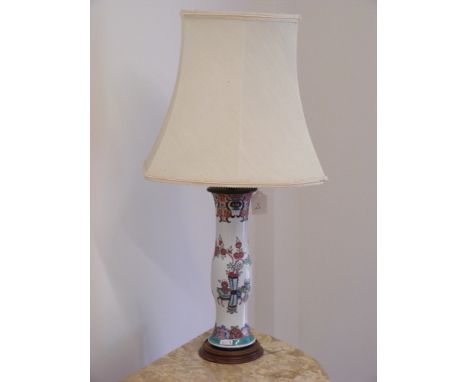 A Chinese ceramic table lamp and shade. Raised on a shaped wooden circular base.