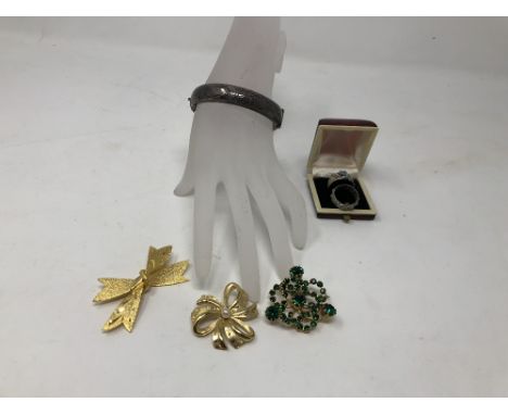 An assortment of costume jewellery including a silver bangle.