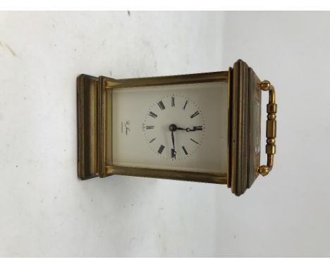 A brass carriage clock inscribed St. James London, 11 jewels to the case (needs service).