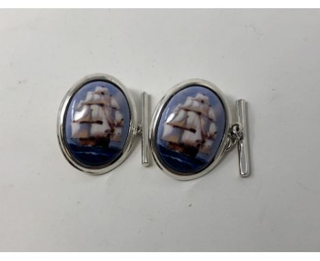 A pair of silver and enamel cufflinks depicting 19th Century sailing ships under full sail.