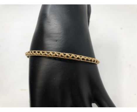 An 18ct gold bangle (marked 750) with wire work decoration, total weight approximately 8.6 grams.