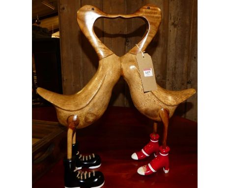 A contemporary carved hardwood model of two kissing ducks, h.50cm