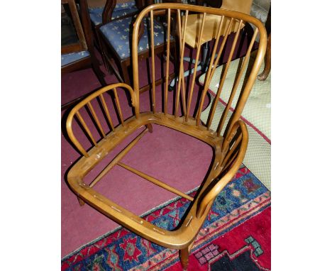 A pair of Ercol mid-elm stickback low armchairs (each lacking webbing and cushioned upholstery), width 80cm