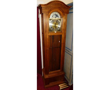 A contemporary oak longcase clock, having moonphase arched silvered and brass dial, glazed trunk door, three-train weight dri