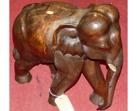 An Eastern stained and carved hardwood model of an elephant in striding pose, h.45cm, length 45cm 