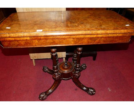 A mid-Victorian figured walnut and strung fold-over card table, raised on turned and fluted columns to scroll acanthus leaf c