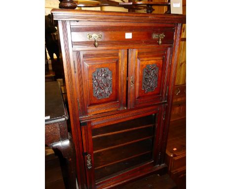 An Edwardian walnut music cabinet, having single upper drawer over relief carved twin cupboard doors to glass inset lower doo