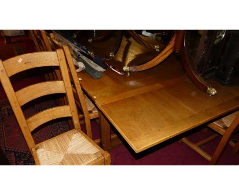 A contemporary honey oak plank top draw leaf refectory table having cleated ends, raised on notch square cut supports, max le