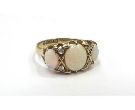 An 18ct gold opal and diamond ring the three oval opals spaced by old cut diamonds. Size R, 3.6g