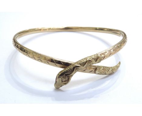 A 9ct gold snake bangle with engraved decoration and ruby set eyes, 6.1g