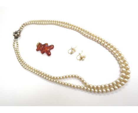 A single strand pearl necklace, an amber pendant as a teddy bear stamped 585 and a pair of faux pearl earrings