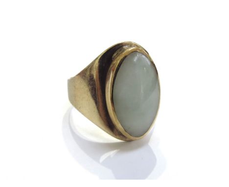 A 9ct gold ring with an elliptical shape pale jade in rubover setting. Size Q, 5.4g