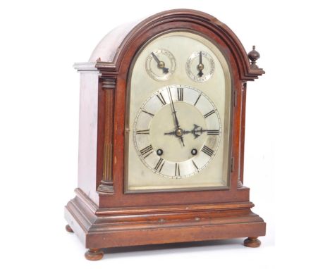 A 19th century mahogany cased eight day bracket mantel clock. Having an arched curved top with flanked finials (af), silver f