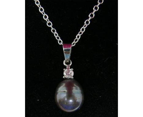 A boxed 14ct white gold pendant set with a round brilliant-cut diamond suspended by a natural grey South Sea pearl on 14ct wh