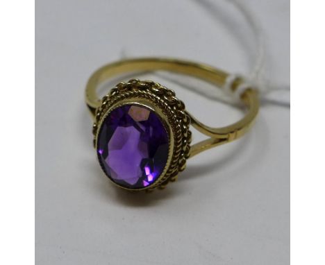 A 9ct yellow gold ring set with a large oval faceted natural amethyst of fine rich purple hue, Size: T, 3g 