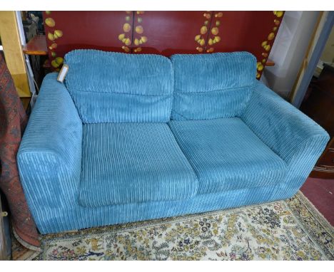 A contemporary sofa bed with blue corduroy upholstery 