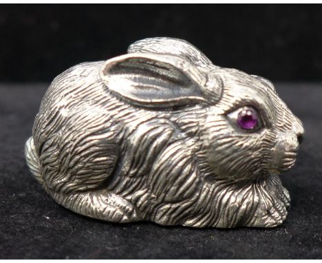 A miniature sterling silver figure of a rabbit inset with faceted ruby eyes 