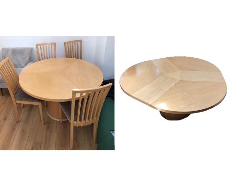 Skovby SM32MB maple dining table, the circular top with rotating action and concealed triple interior leaves, raised on a cyl